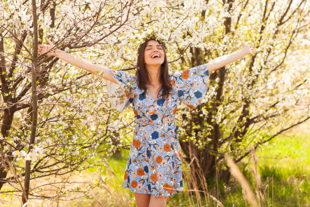 mulher super feliz com os braços abertos está desfrutando o espírito da primavera! - floral dress - fotografias e filmes do acervo