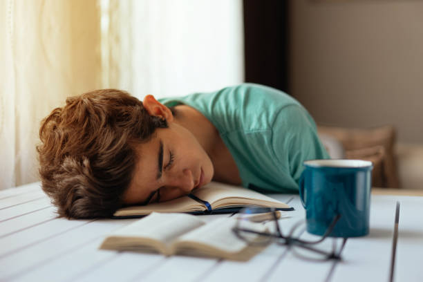 adolescente durmiendo mientras estudiaba en el escritorio - sleeping high school desk education fotografías e imágenes de stock