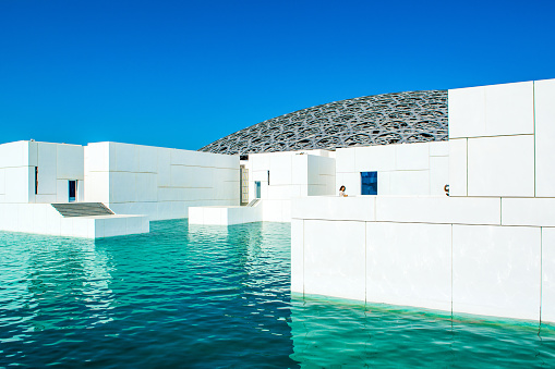 Abu Dhabi, UAE - 27 March 2018: A spectacular and unique  exterior of the Louvre Abu Dhabi museum with dome and sea lagoon, opened on the Saadiyat island
