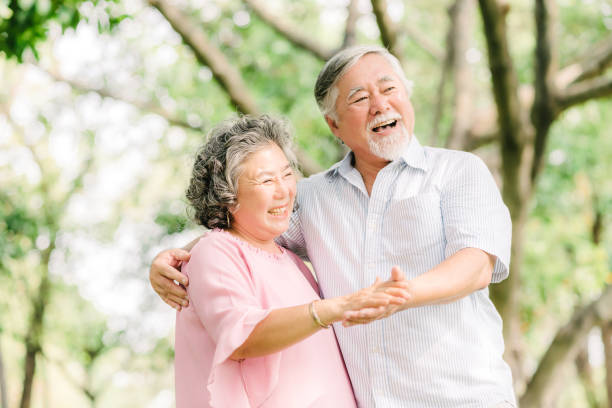 istock senior Asian couple dancing in the park 950451334