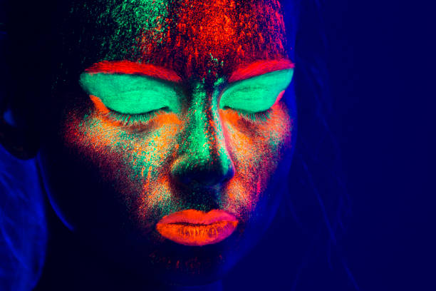 istock Women Portrait with Glowing Colored makeup in black light 950451564