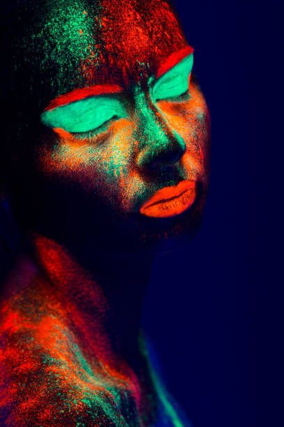 istock Women Portrait with Glowing Colored makeup in black light 950451896