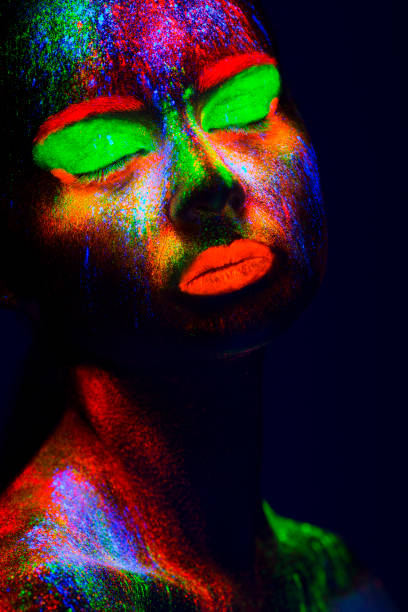 istock Women Portrait with Glowing Colored makeup in black light 950451914