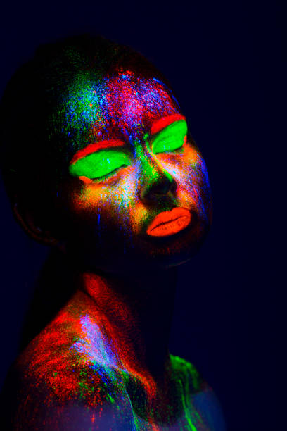 istock Women Portrait with Glowing Colored makeup in black light 950451962