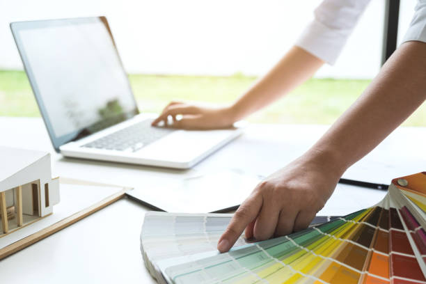 istock interior design or graphic designer working on project of architecture drawing with work tools and color swatches, colour chart in digital tablet at workplace 950452180