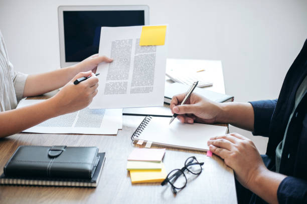 istock Two high school students campus or classmates with helps friend studying for a test an exam in workbook learning in classroom, Tutor books with friends, Education school concept 950455798