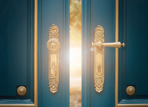 antique ornate gold door handle closeup on blue wooden door