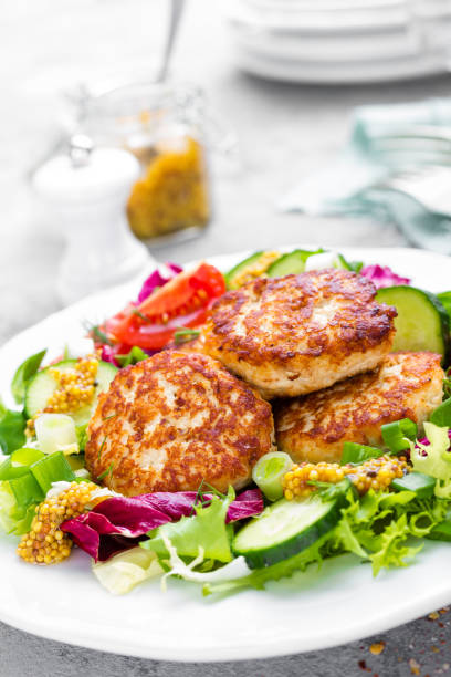istock Cutlets and fresh vegetable salad on white plate. Fried meatballs with vegetable salad 950459876