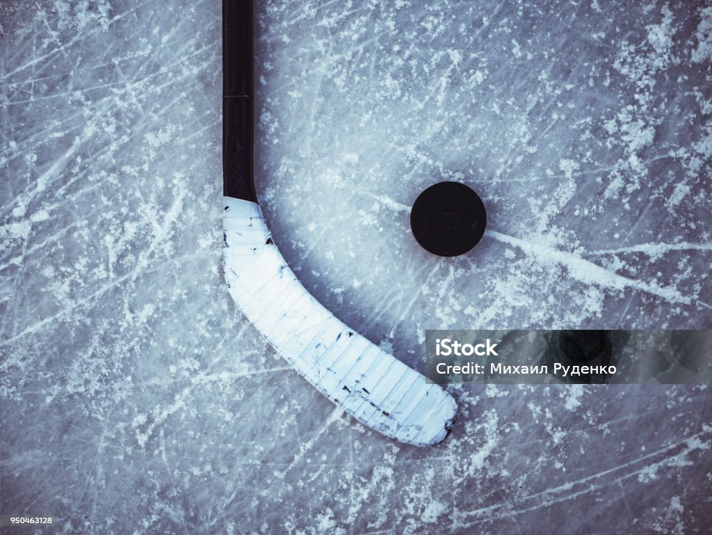hockey puck and stick laying on the textured ice close up copyspace Hockey Stock Photo