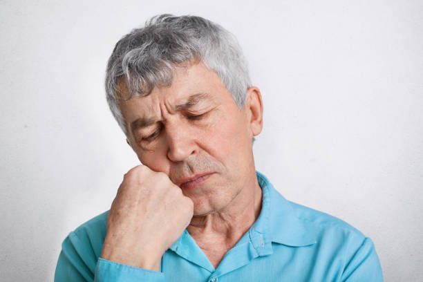 istock Thoughtful elderly male with pensive expression, feels lonely, keeps hand under chin and contemplates about his life, keeps eyes shut, isolated over white background. People, age and wisdom concept 950463308