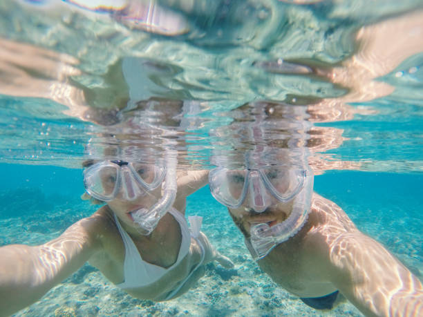 istock Young man taking action camera selfie in crystal blue water, vacations summer concept 950472832