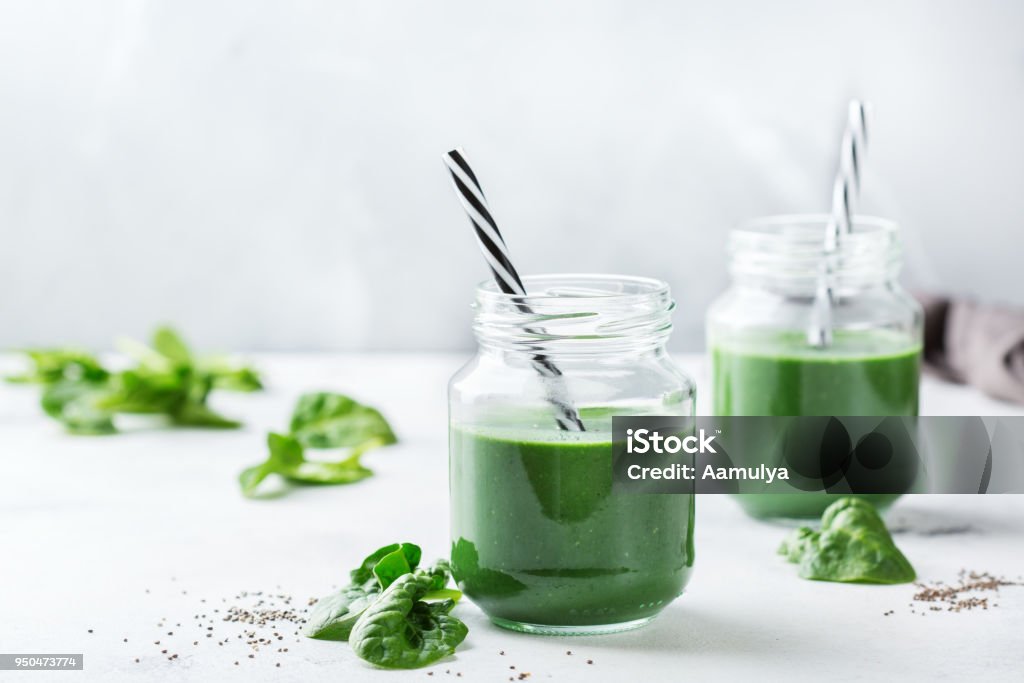 Healthy green vegan smoothie with spinach, spirulina and chia seeds Food and drink, dieting and nutrition concept. Healthy green vegan smoothie with spinach leaves, spirulina and chia seeds for detox in summer days Smoothie Stock Photo