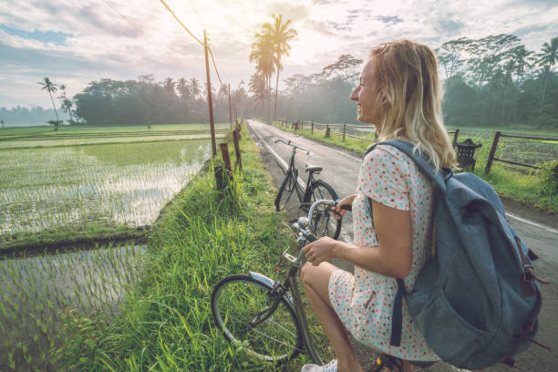 istock Young woman on bicycle stops to admire rice fields, Indonesia 950474524
