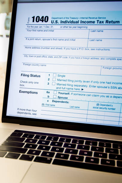 istock Filing on Laptop, IRS Form 1040, Individual Income Tax Return 7 950478702