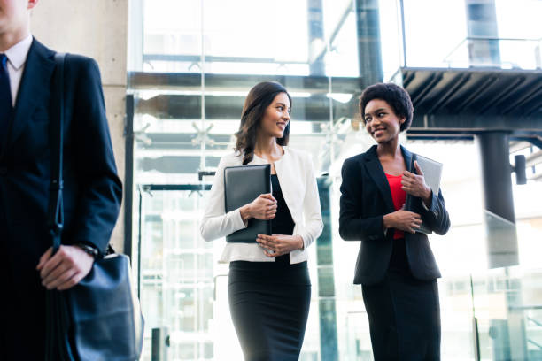 istock Two young female colleagues walking side by side and smiling 950484526