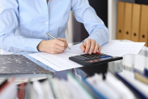 istock Female bookkeeper or financial inspector  making report, calculating or checking balance. Internal Revenue Service checking financial document. Audit concept in busines 950489018