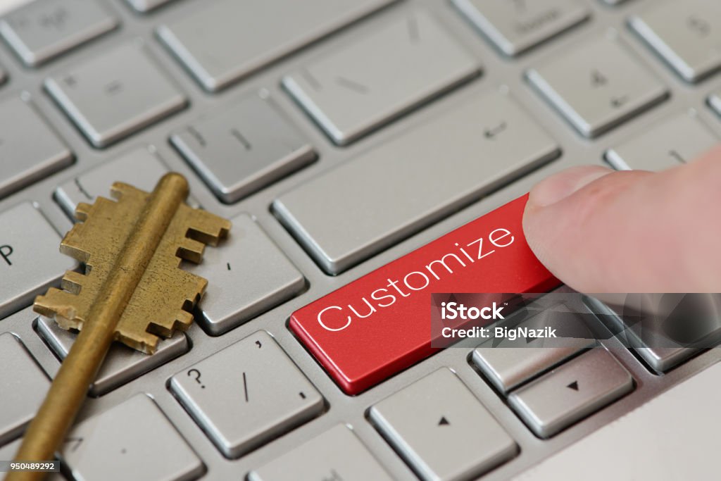 A finger press a button with text Customize on a keyboard A finger press a button with text Customize on a keyboard. Customized Stock Photo