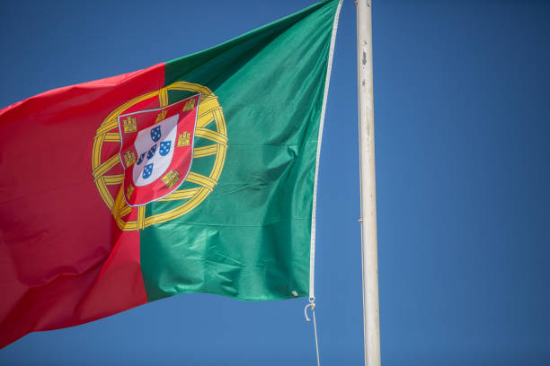 istock Portugal flag flying in sunshine from a white flag pole 950493084