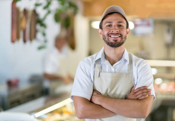 man working at the butcher's shop - butchers shop imagens e fotografias de stock