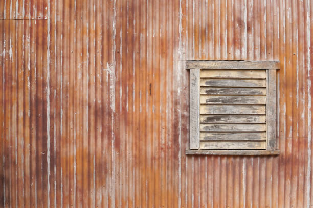 hierro corrugado. una textura de pared de hierro oxidado corrugado con ventana de madera. - corrugated iron rusty old iron fotografías e imágenes de stock
