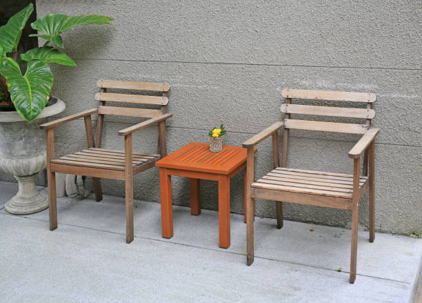 istock Wood chairs with mini wood table against rug cement wall. 950506462