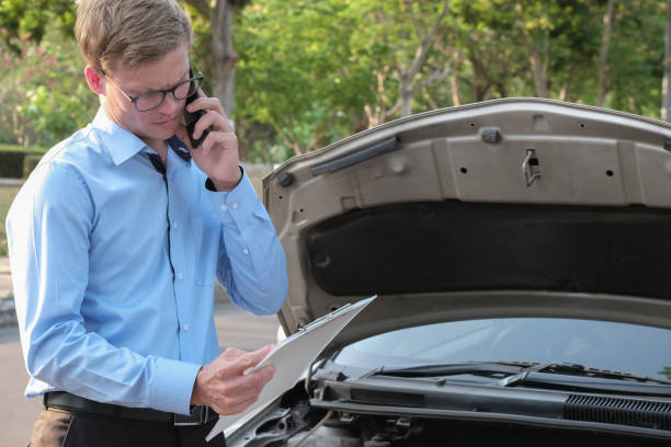 istock male agent examining engine for filling auto insurance form. caucasian man calling for assistance for car damaged by traffic accident 950511630