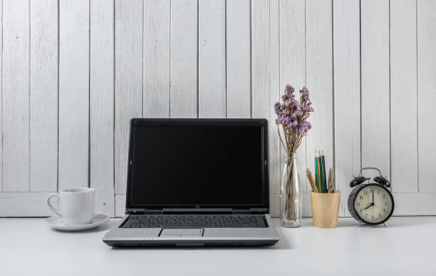 istock workplace background with Blank white screen modern laptop computer. White wooden vintage blackground 950523178
