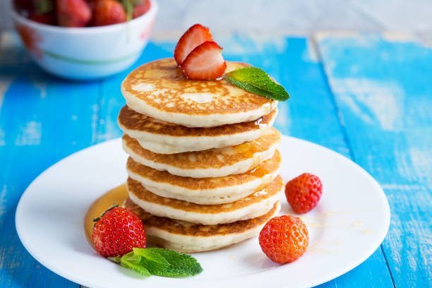 istock Stack of pancakes (fritters) with strawberries and honey on a plate. 950523488