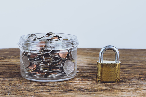 Gold and metal Padlock and full coins with jar. Save Money Concept and used for financial protection inferences or other investment messages