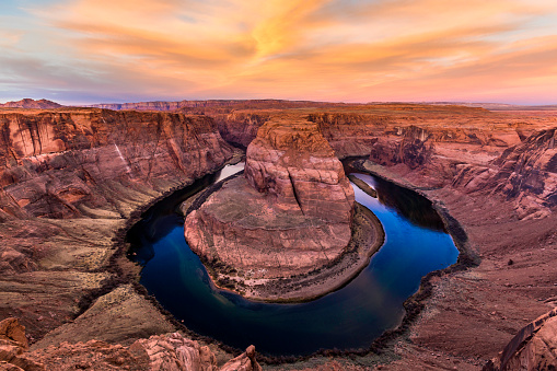 Stock photo of the gorgeous Horeshoe bend in Page Arizona at Sunrise with beautiful orange cloudscape.