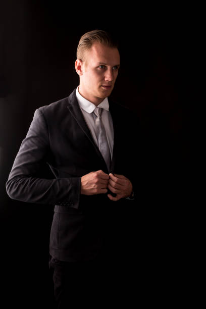 istock Handsome Businessman with black suit isolated on black background 950535566
