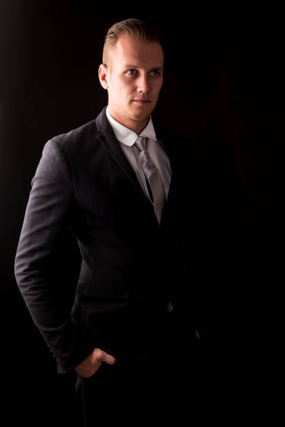 istock Handsome Businessman with black suit isolated on black background 950535580