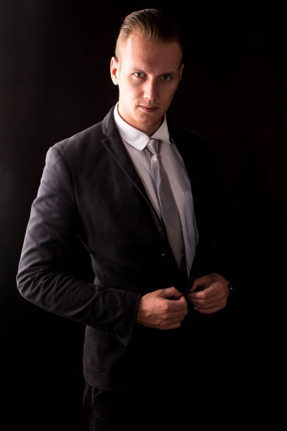 istock Handsome Businessman with black suit isolated on black background 950535582