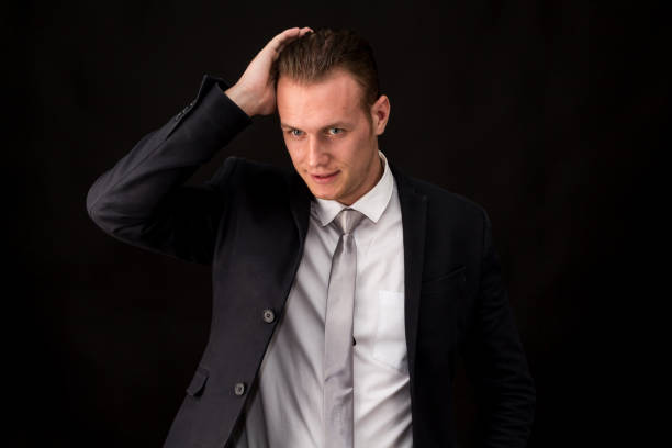 istock Handsome Businessman with black suit isolated on black background 950536118