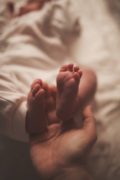 istock Baby feet in mother hands 950540628