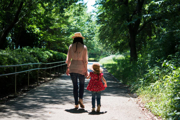 istock Mother and daughter walking in the park 950546894