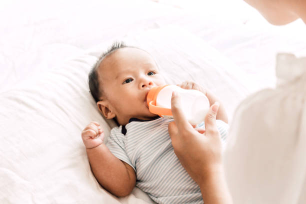 istock Mother feeding baby from milk bottle 950554506