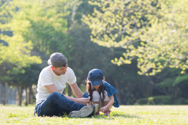 父と娘が芝生で遊ぶ - 子ども　父親 ストックフォトと画像