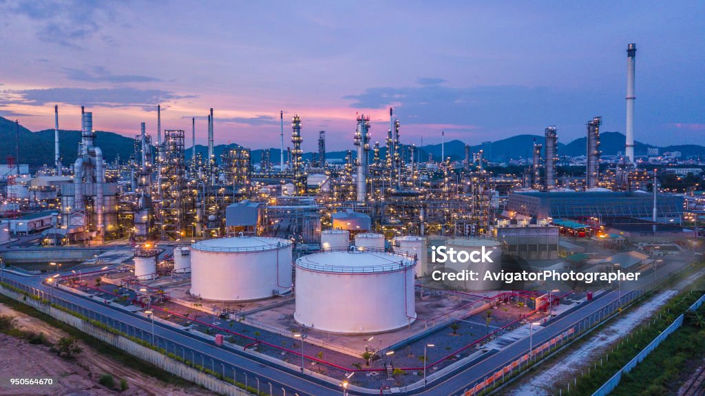 Aerial top view oil and gas chemical tank with oil refinery plant background at twilight. Refinery Stock Photo