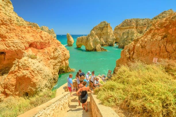 Lagos, Portugal - August 22, 2017: tourists on stairs awaiting boat trip for caves, arches and rock formations of Ponta da Piedade in Lagos, one of the main tourist destinations in the Algarve Coast.