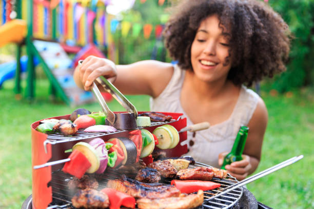 istock Smiling woman preparing barbecue at backyard 950567654