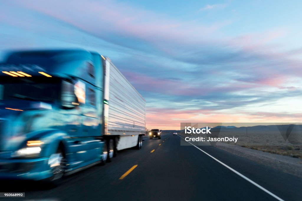 Sunset on the Long Haul Highway Stock photo from a driver of a vehicles point of view at sunset on a highway with passing cars and trucks. Semi-Truck Stock Photo