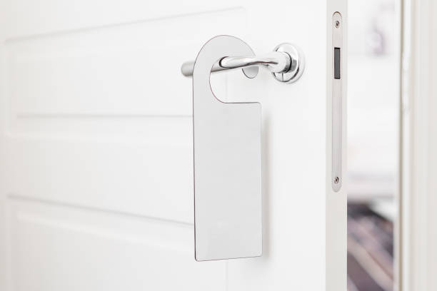 istock Door knob with empty label on a door handle for your text. Empty white flyer mockup hang on door handle. Leaflet design on entrance doorknob. Dont disturb sign. Hotel room clear hanger. blank 950573742