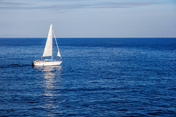 красивый морской пейзаж, белый парусник в синем море - sea water single object sailboat стоковые фото и изображения