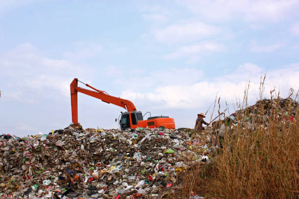 istock Backhoe working on garbage dump at landfill. People Working at a Landfill. 950587686
