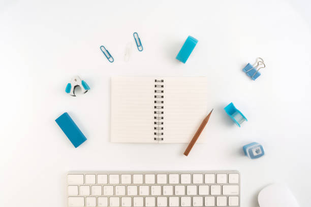 istock Flat lay, top view office table desk. Workspace with blank note book, keyboard, Blue office supplies and coffee cup on white background. 950587908