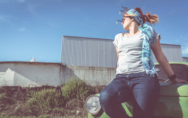istock Redhead girl posing on car hood 950590658