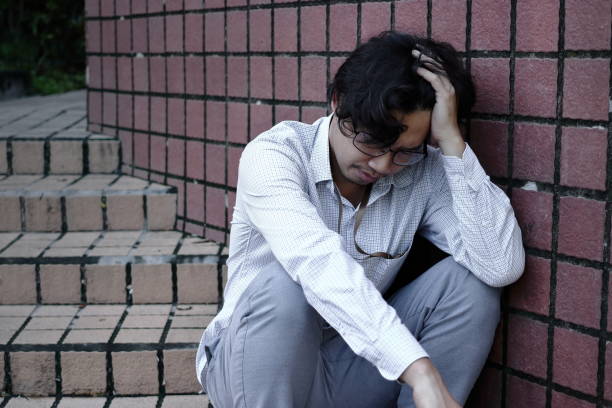 istock Depressed  stressed young Asian business man with hands touching head and feeling disappointed or exhausted with job. 950598956
