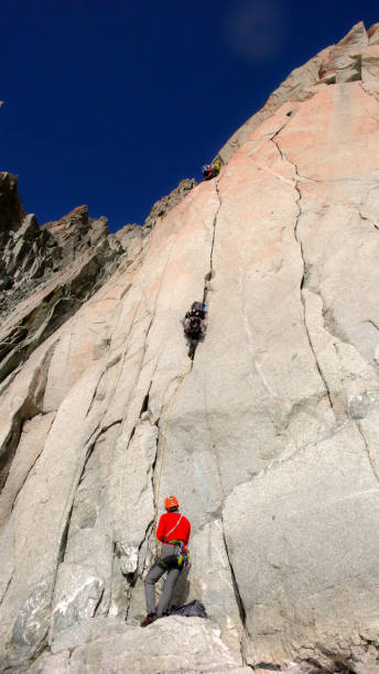 istock two rock climbers on a difficult route in a vertical granite wall in the French Alps under a blue sky 950599796
