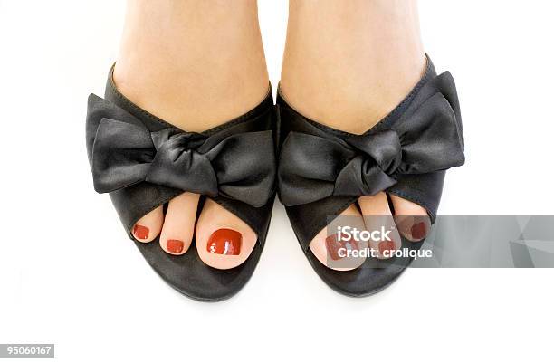 Manicured Red Toes In Black Shoes Over A White Surface Stock Photo - Download Image Now